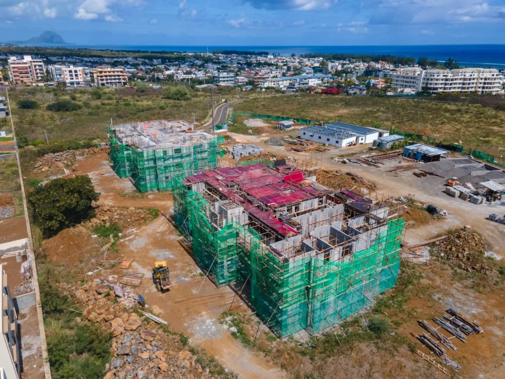 Oblique aerial view of the Anna City site with the second block’s top slab formwork in place and Le Morne on the horizon